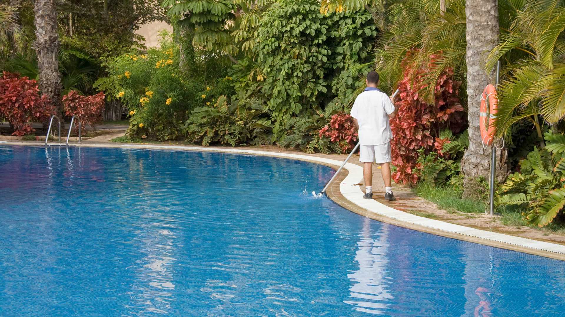 Person cleaning pool. Year-round pool care.