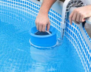 a person holding a blue bucket in a pool