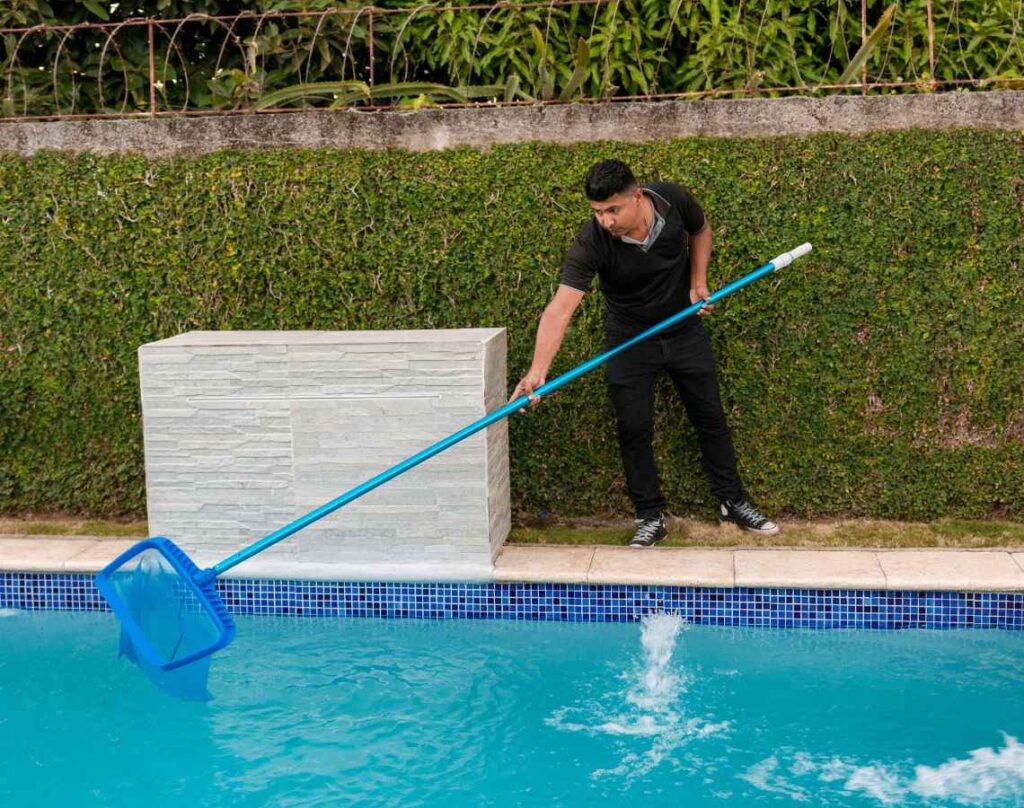 Person cleaning pool with net. Pool cleaning robots.