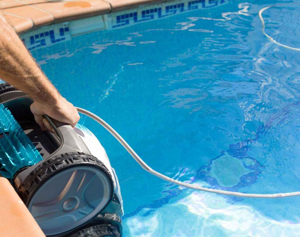 Person holding pool cleaning robot. Pool cleaning robots.