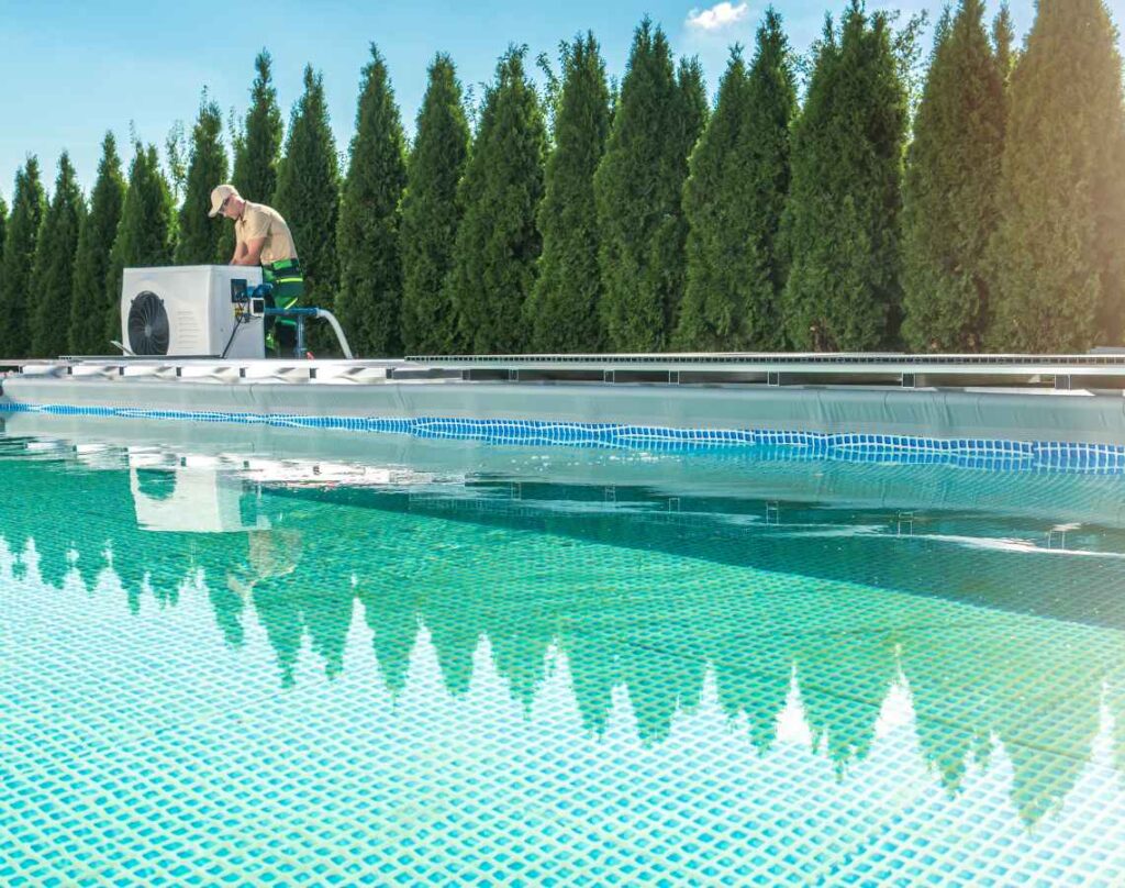 Person with pool pump next to trees. Energy-efficient pool pumps.
